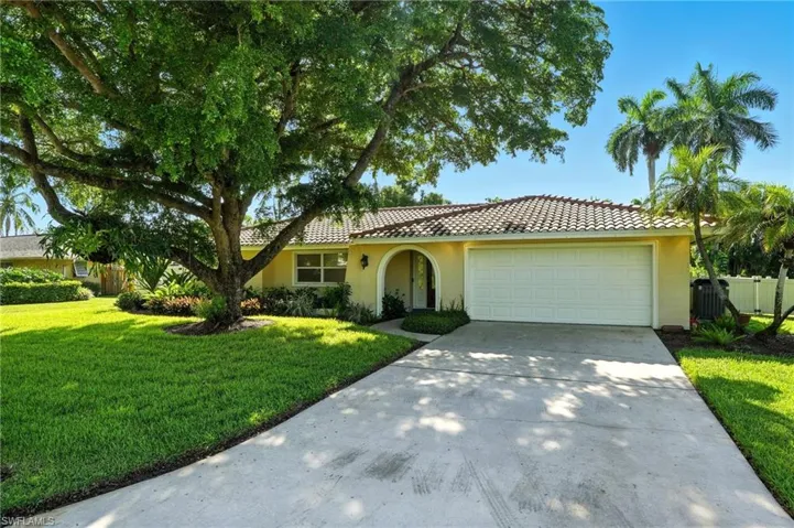 View of front of home with concrete driveway, stucco siding, an attached garage, and a tiled roof