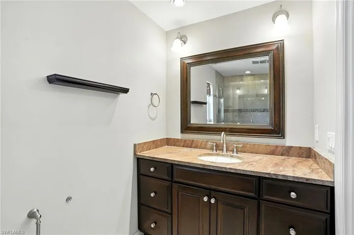 Bathroom featuring vanity and a tile shower