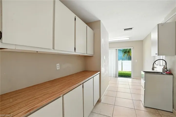 Kitchen featuring white cabinets, light tile patterned flooring, and light countertops