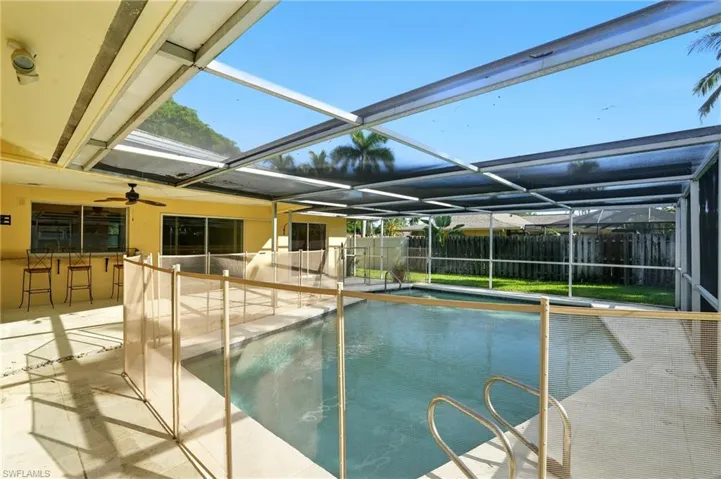 View of swimming pool featuring a patio area, a sunroom, and a lanai