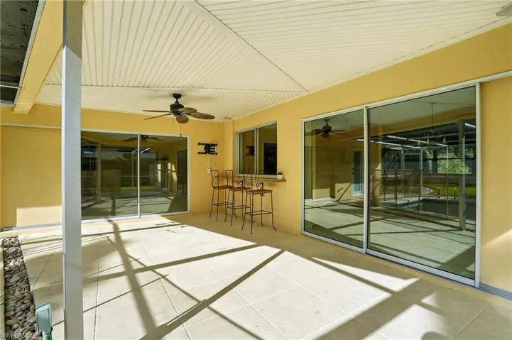 View of pool with a patio area, glass enclosure, a sunroom, and ceiling fan