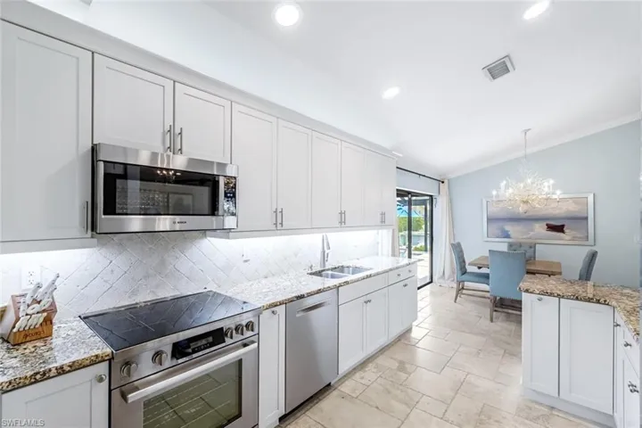 Bright & open kitchen with Bosch appliance package and level 3 granite countertops. Receessed lighting and under cabinet lighting. There is multicolored above cabinet lighting as well.