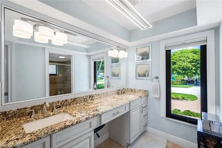 Primary bathroom with spa-inspired finishes offering dual vanities with Level 3 granite. Tray ceiling, contemporary lighting