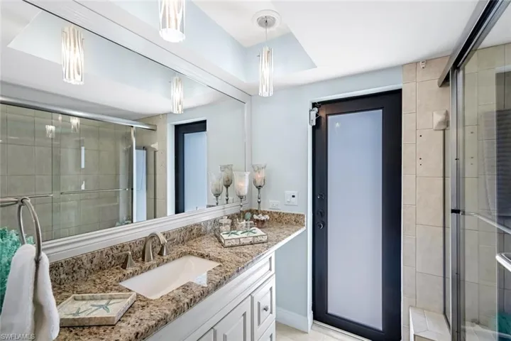 Guest bathroom with access to lanai features a shower/tub combo. Single vanity with a dressing area.