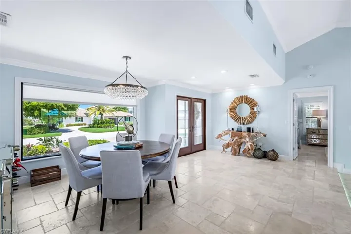 Formal dining room with large picture window open to formal living room