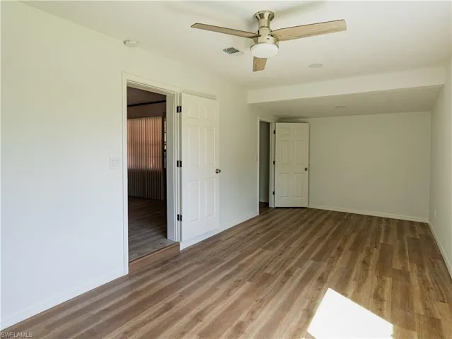 Unfurnished room with hardwood / wood-style floors and ceiling fan