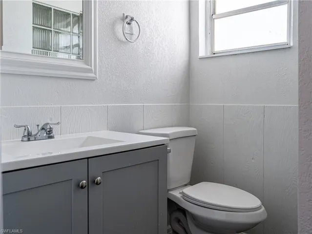 Bathroom with a healthy amount of sunlight, toilet, and large vanity