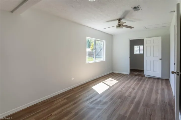 Empty room with a textured ceiling, ceiling fan, and hardwood / wood-style floors