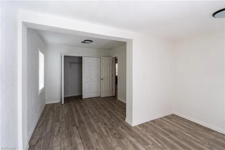 Unfurnished bedroom with hardwood / wood-style flooring and a closet