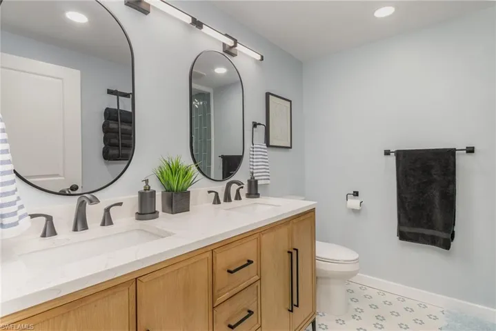 Full bathroom with double vanity and recessed lighting