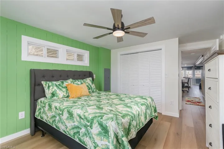 Bedroom featuring light wood finished floors, a closet, and a ceiling fan