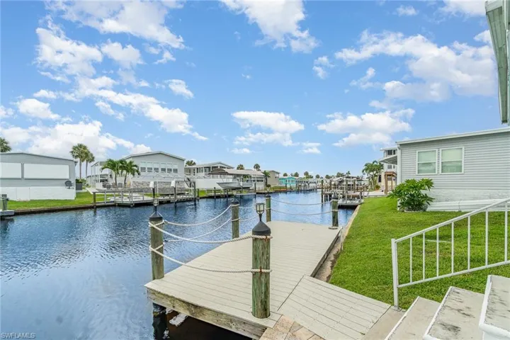 Dock featuring a water view, a yard, and a residential view