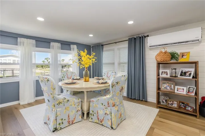 Dining room featuring a wall mounted air conditioner, wood finished floors, and recessed lighting