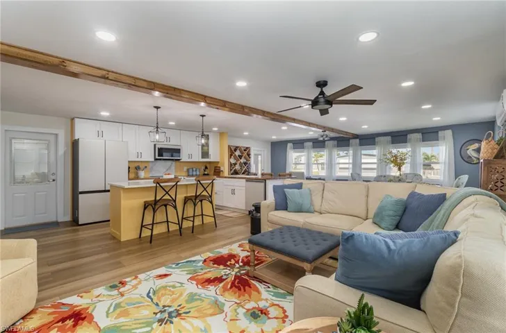Living area featuring recessed lighting, a ceiling fan, light wood-style floors, and beamed ceiling