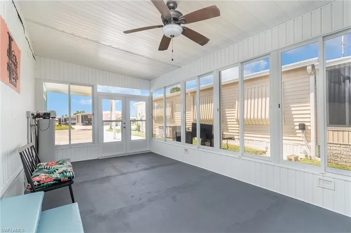 Unfurnished sunroom with french doors and ceiling fan