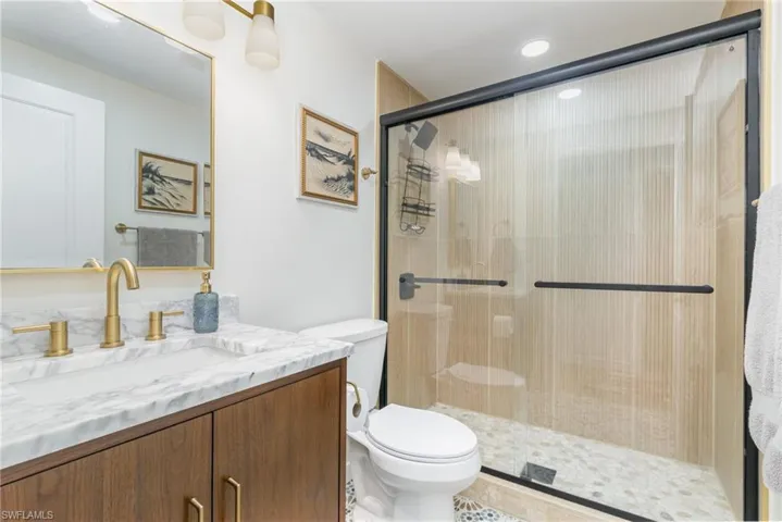 Full bath with vanity, a stall shower, and recessed lighting