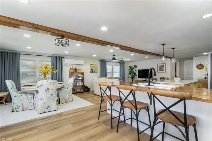 Kitchen featuring light wood finished floors, beamed ceiling, recessed lighting, light countertops, and a ceiling fan