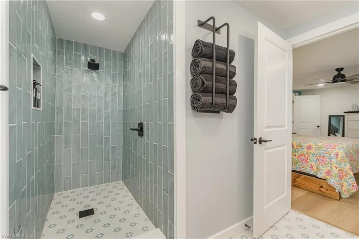 Ensuite bathroom with a tile shower, recessed lighting, and ceiling fan