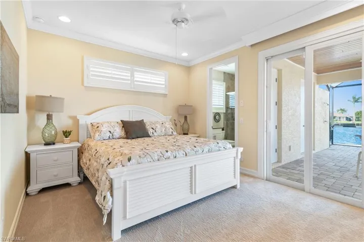 Carpeted bedroom featuring access to exterior, connected bathroom, ceiling fan, and crown molding