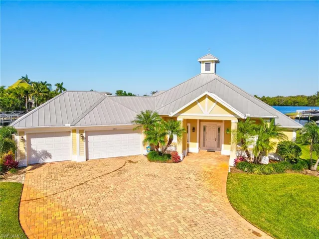 View of front of property featuring a garage, a water view, and a front yard
