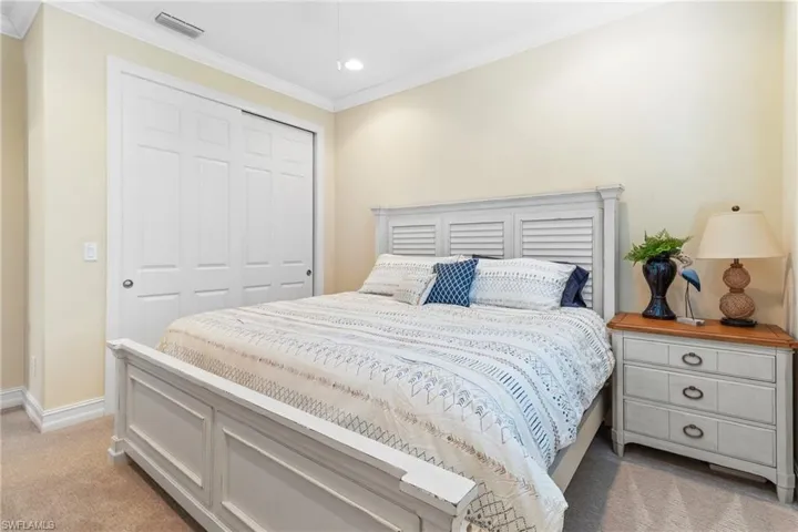 Bedroom featuring crown molding, a closet, and light colored carpet