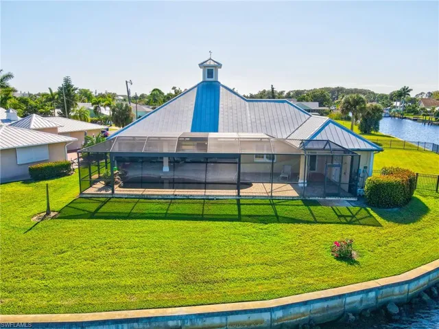 Back of property featuring a lanai, a yard, and a water view
