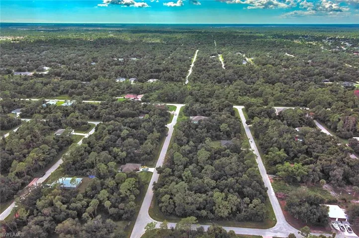 Aerial view of property and surrounding area featuring a heavily wooded area
