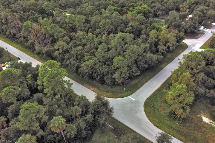 Aerial view of property and surrounding area featuring a forest