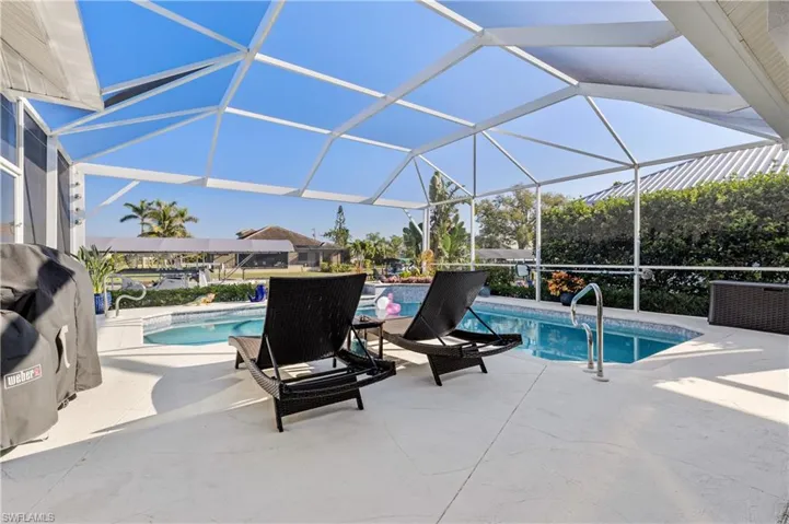 Pool featuring glass enclosure and a patio area