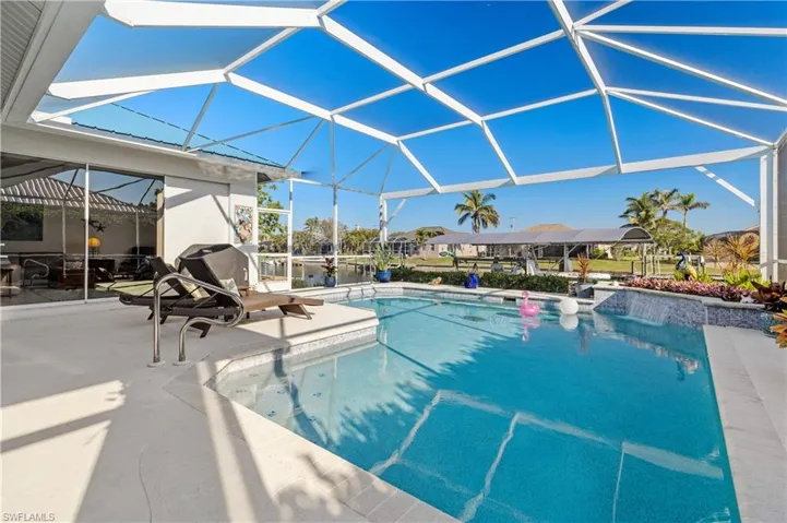 Outdoor pool with a lanai, a grill, and a patio area