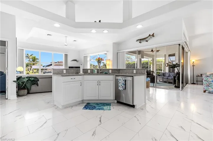 Kitchen with marble finish floor, a wealth of natural light, a ceiling fan, and dishwasher