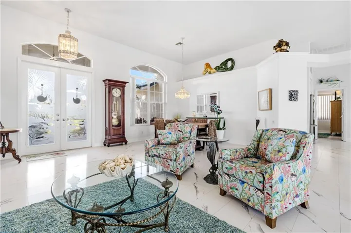 Living room with french doors, marble finish floor, a chandelier, and visible vents