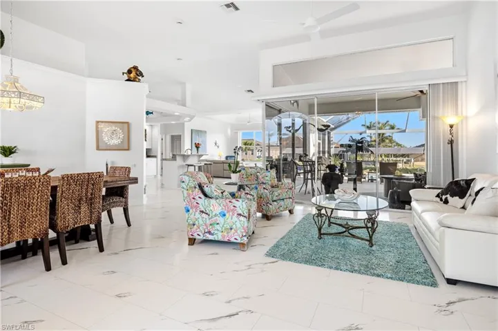 Living area with marble finish floor, visible vents, plenty of natural light, and ceiling fan