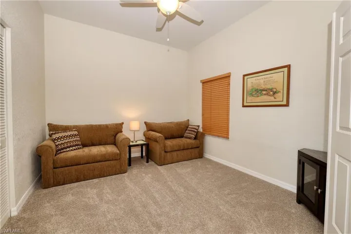 Living area featuring light carpet and ceiling fan