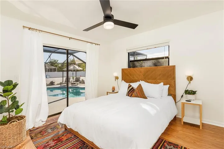 Bedroom featuring multiple windows, access to outside, a sunroom, and light wood-type flooring