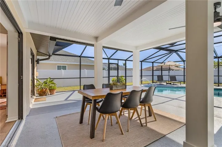 Sunroom with outdoor dining area, a patio area, and beam ceiling