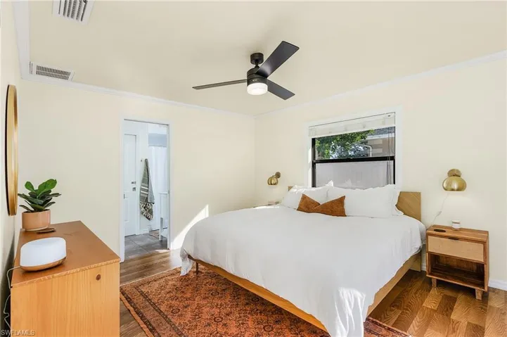 Bedroom featuring wood finished floors, ornamental molding, and ceiling fan