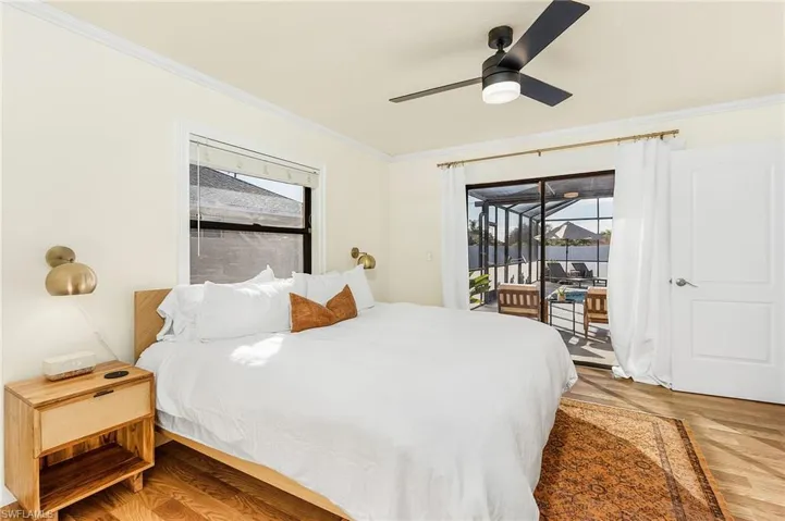 Bedroom featuring light wood-style flooring, access to outside, a ceiling fan, and crown molding