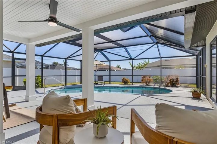 View of pool with a sunroom, a patio area, glass enclosure, and a fenced backyard