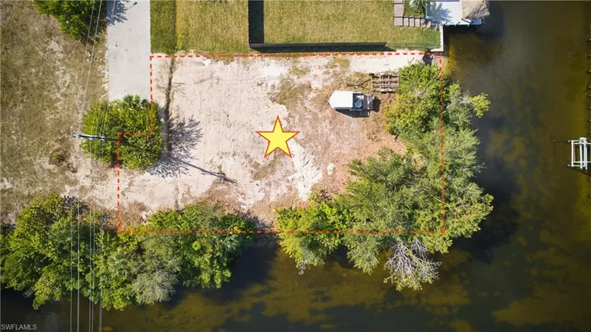 Waterfront parcel featuring mature trees, a concrete access path, and direct water access