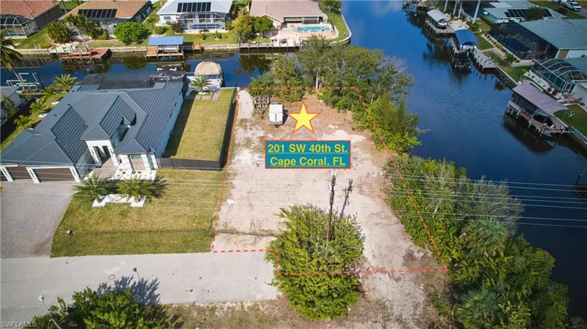 Canal-front lot with existing utility pole and mature landscaping