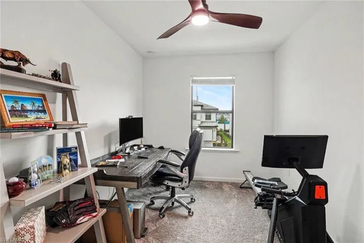 Carpeted room with a ceiling fan, a window, and white walls