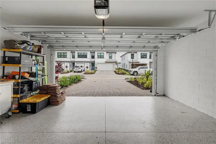 Attached garage featuring epoxy-coated flooring and concrete block walls