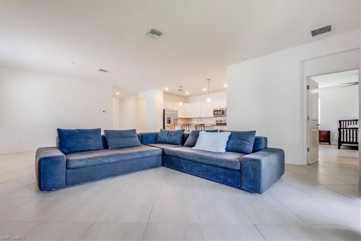 View of tiled living room and lovely kitchen.