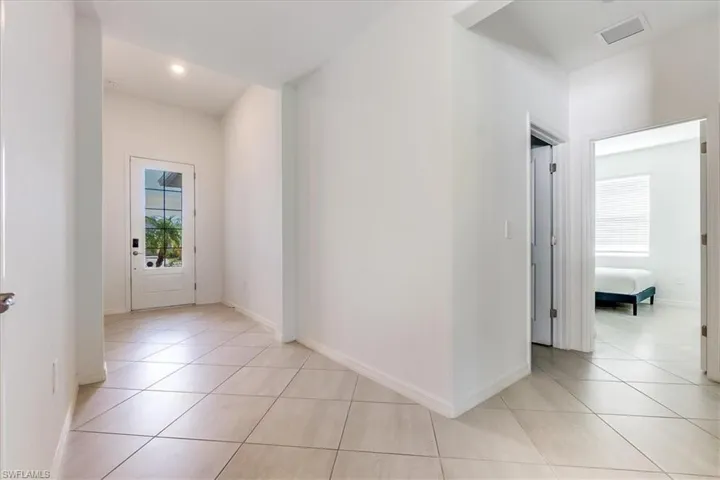 Hallway featuring light tile floors