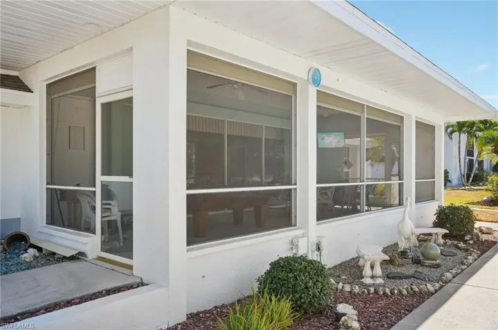 View of home's exterior with a sunroom and stucco siding