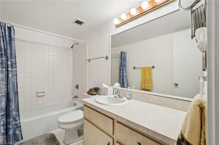 Bathroom featuring shower / bath combo, vanity, and light tile patterned floors