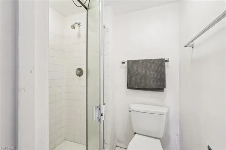Full bathroom featuring a shower stall and toilet