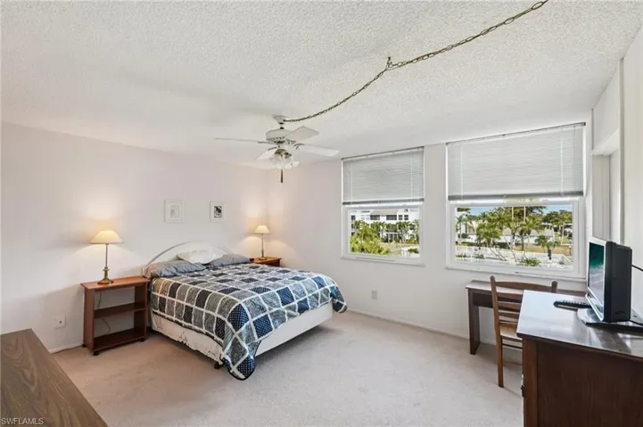 Bedroom featuring carpet flooring, a ceiling fan, and a textured ceiling