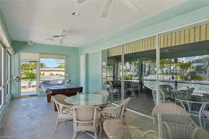 Sunroom with outdoor dining space, ceiling fan, and a patio